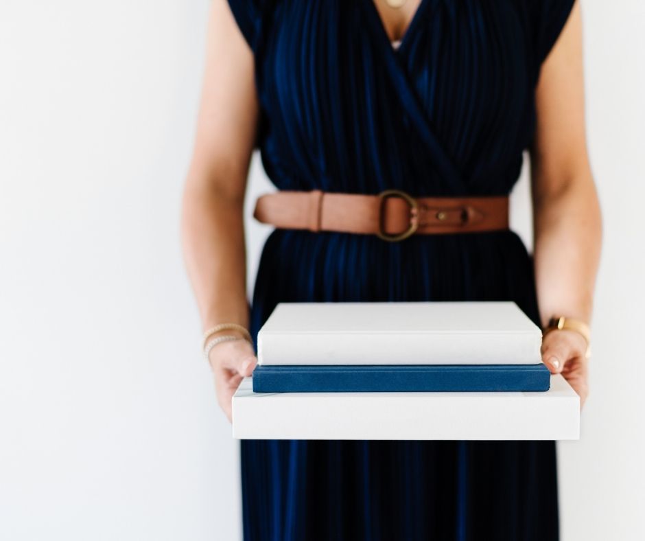 woman holding stack of books
