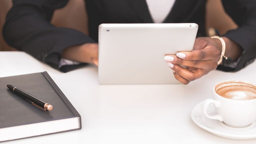 A dietitian on an ipad checking in on her clients at a coffee shop