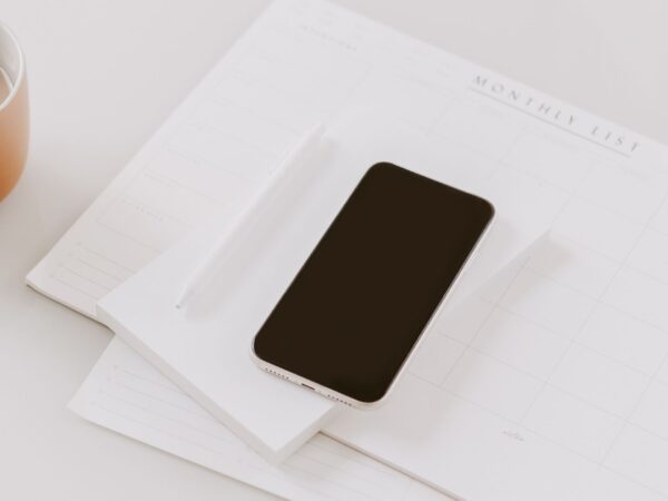 a cell phone on top of a monthly planner on a desk