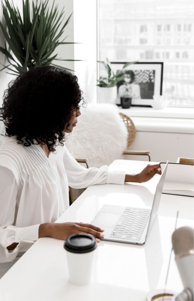 Woman working at her desk with her laptop and notebook