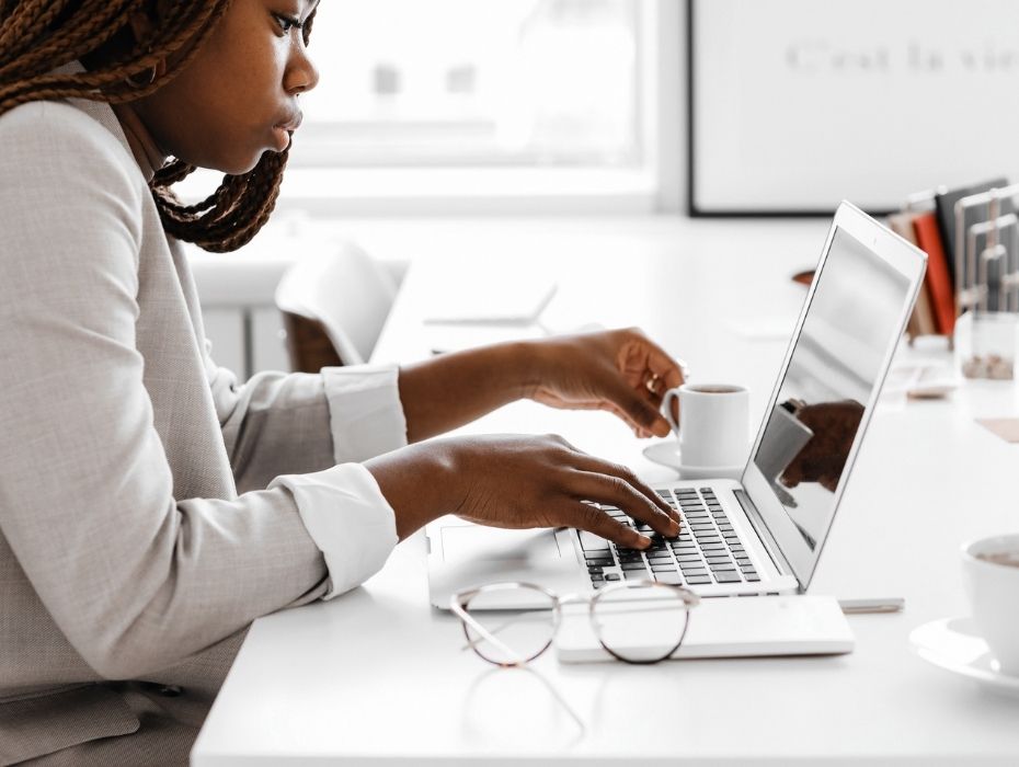 woman sitting at desk concentrating on work with laptop open