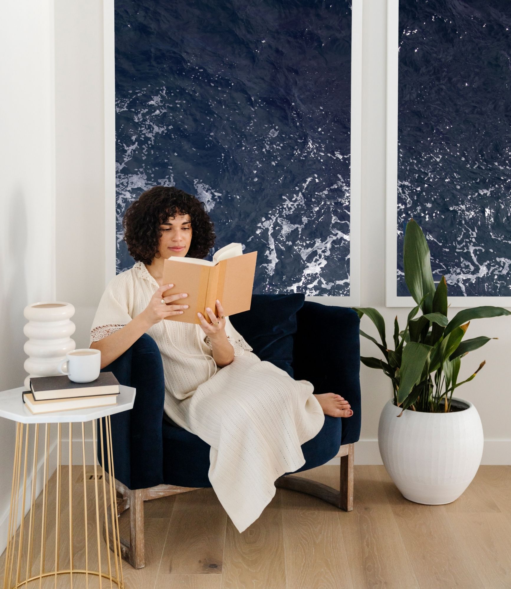woman reading in a comfy chair and cup of coffee on side table