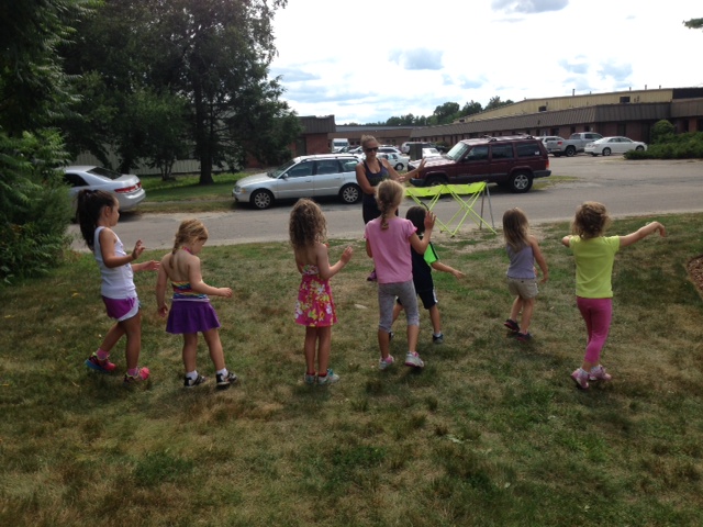 Children participating in a kids dance class outside in the grass.